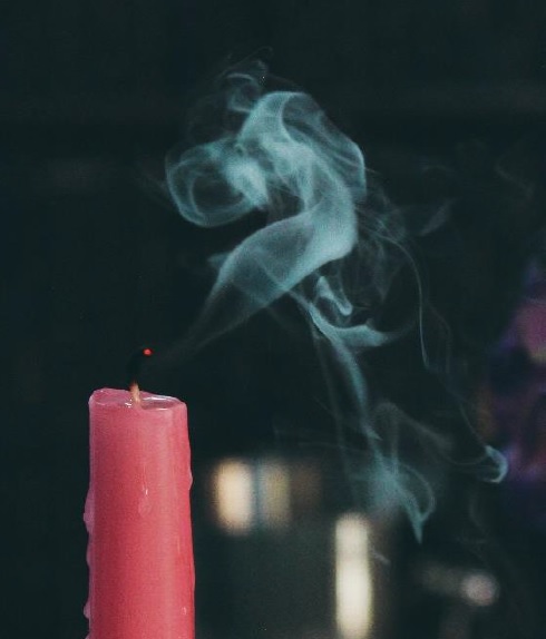 Pink candle blown out, with smoke lingering in the air